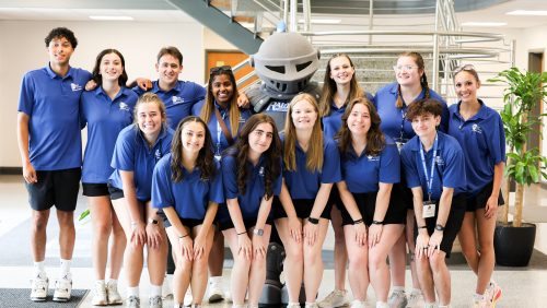 Rivier students with Raider mascot